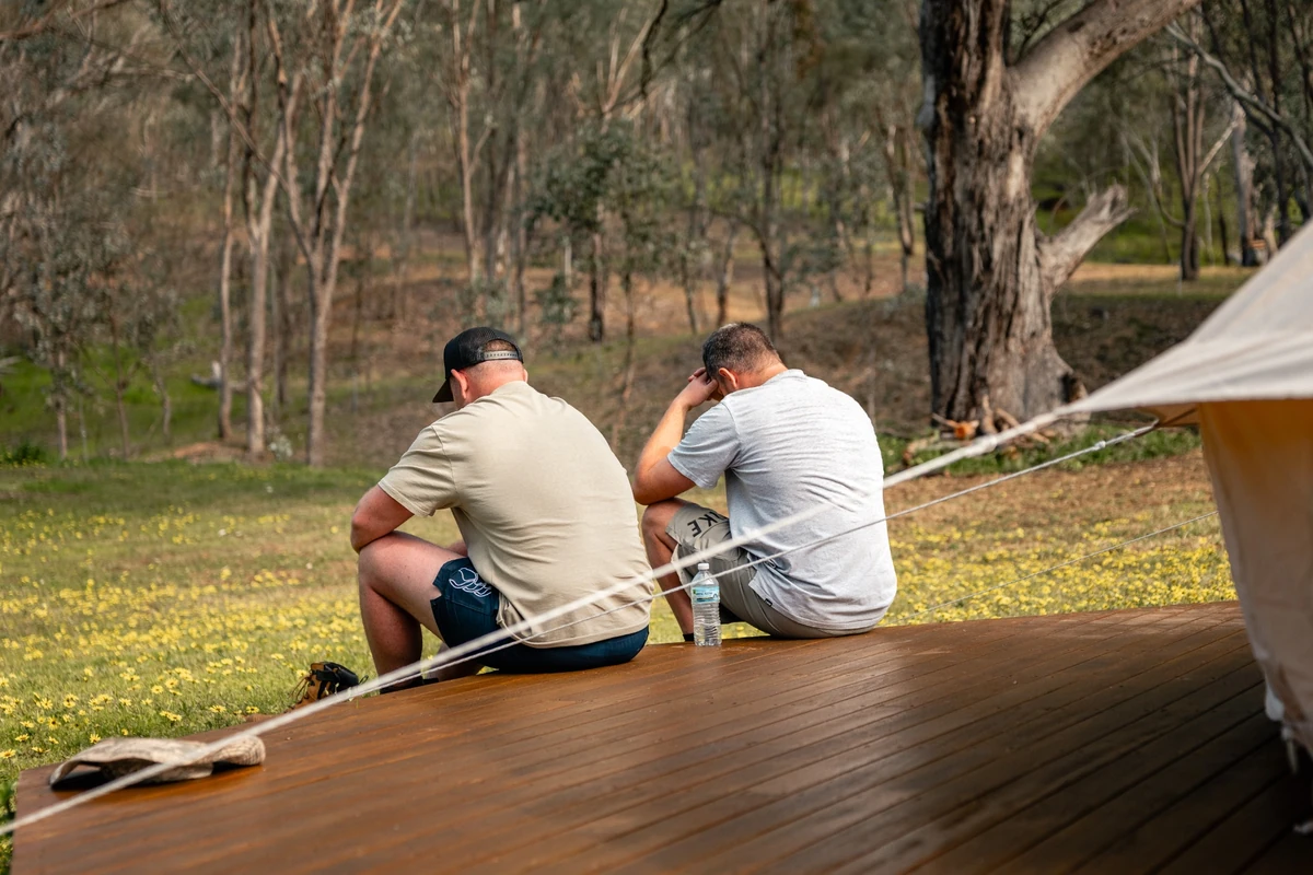 Men gathered near a fire during a workshop